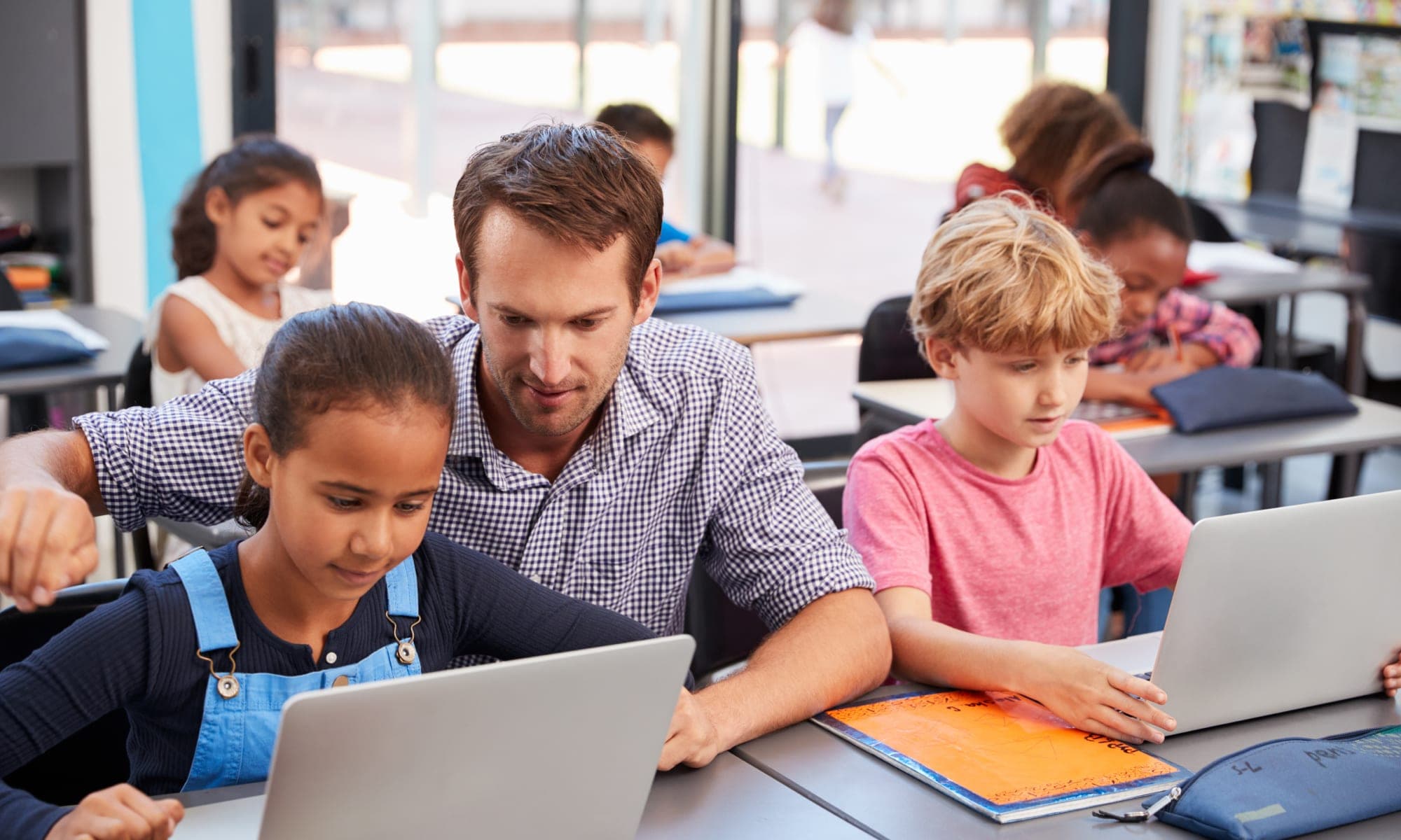 Teacher with students. Safeguarding students online.