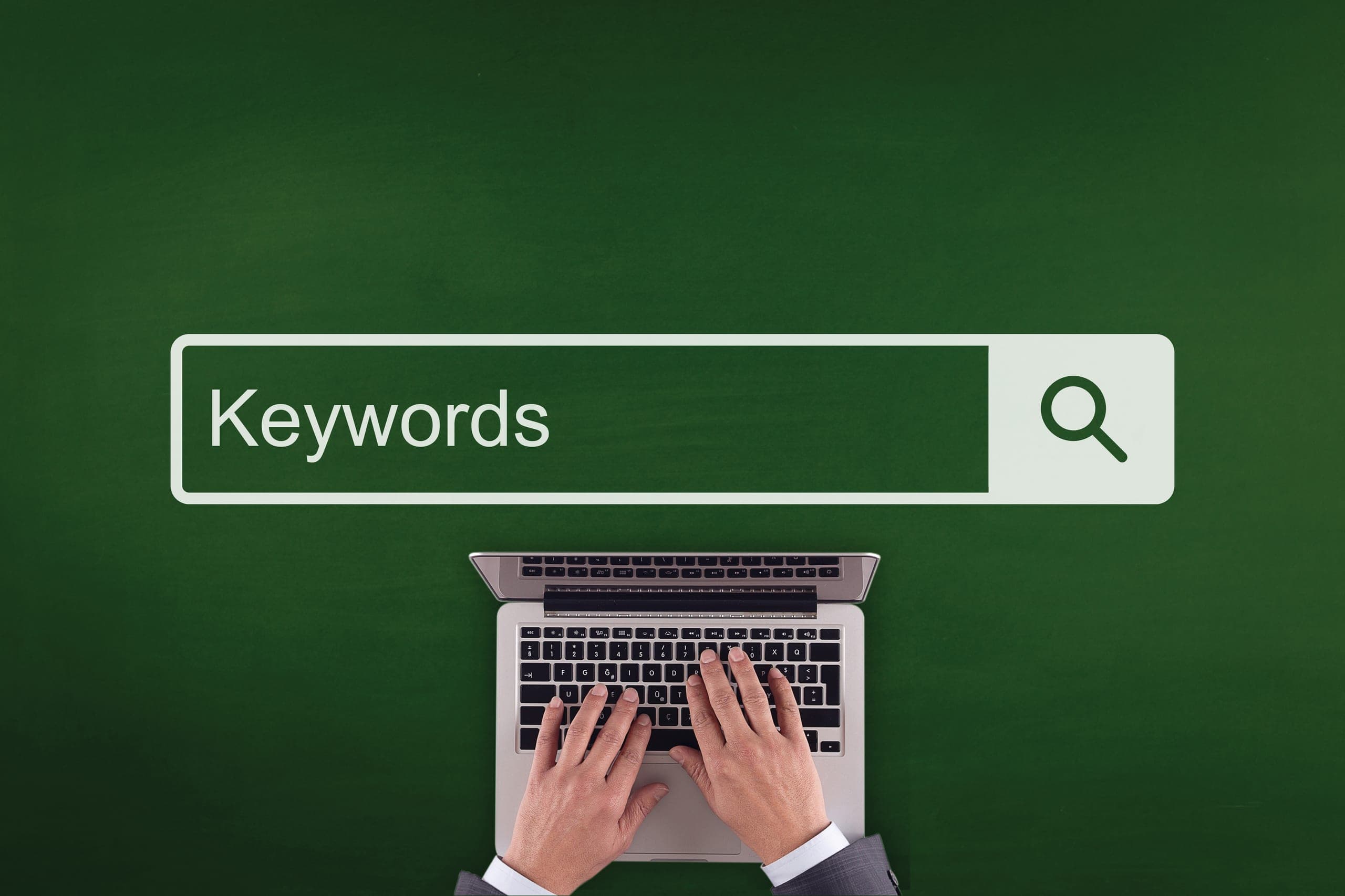 Overhead shot of a man typing keywords into his laptop