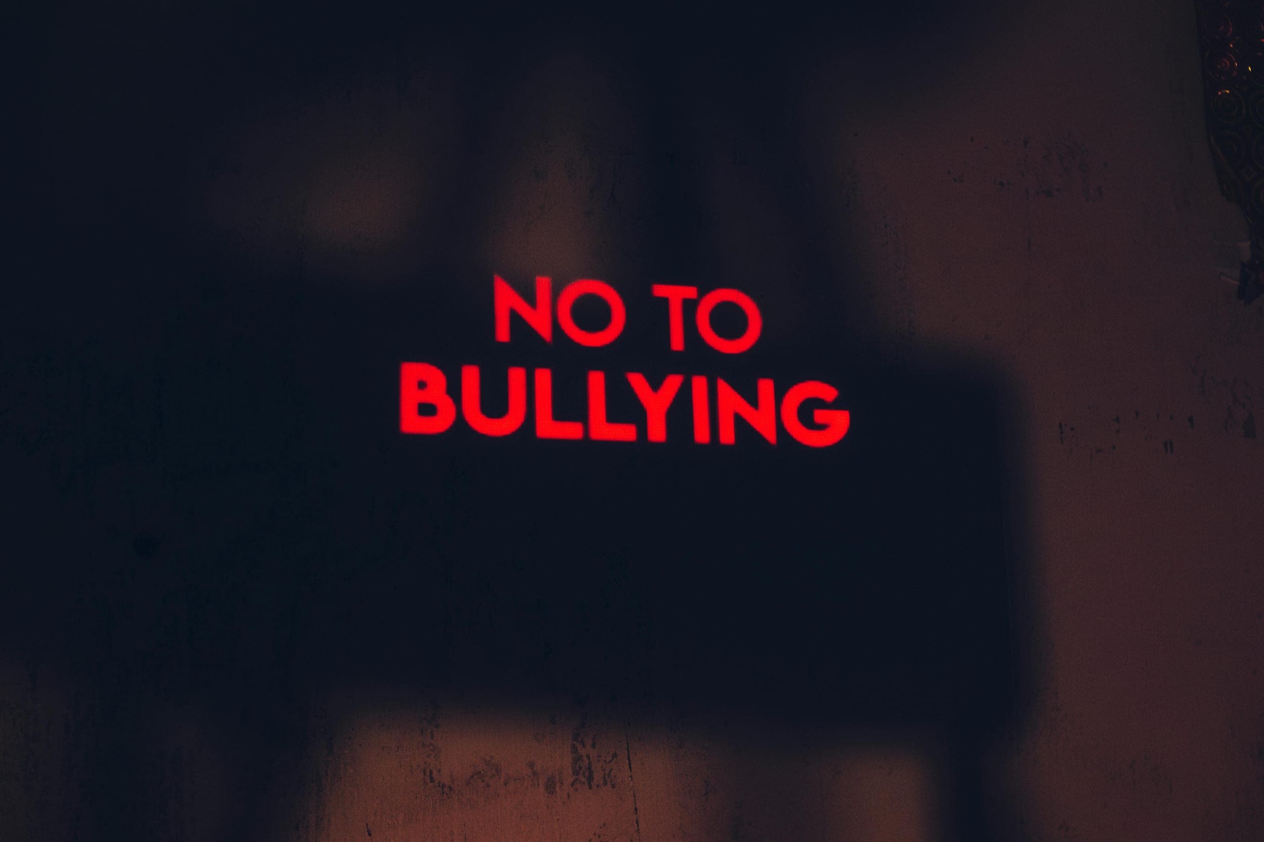Red 'say no to bullying' sign on black background